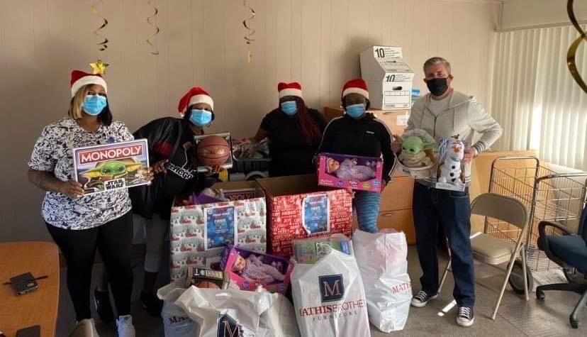 Sistas Making a Difference and Supervising Deputy Public Defender Dave McClave pose with toys for the Sistas' holiday toy drive