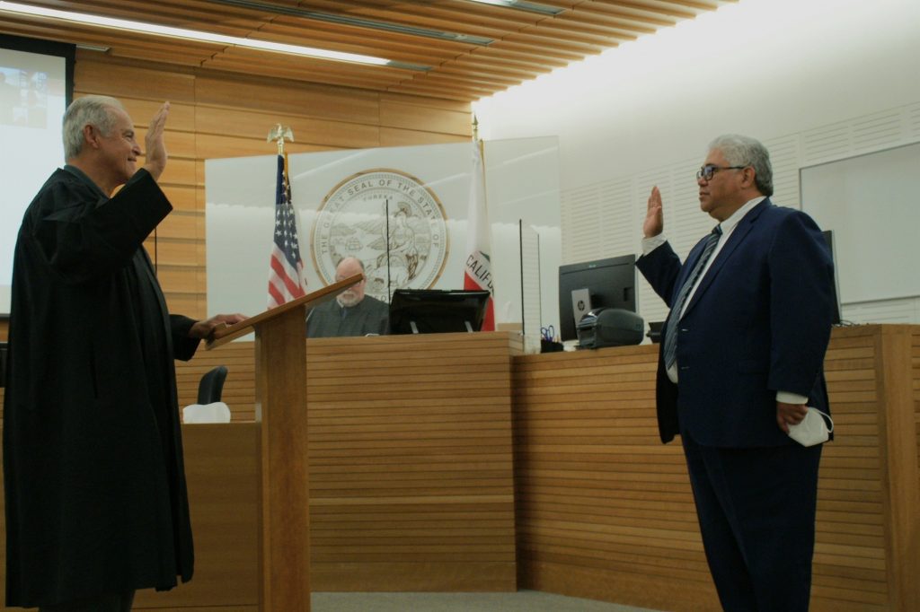 Judge John Pacheco, standing on left, swears in Judge Kawika Smith, right, at the San Bernardino Justice Center.