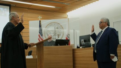 Judge John Pacheco, standing on left, swears in Judge Kawika Smith, right, at the San Bernardino Justice Center.