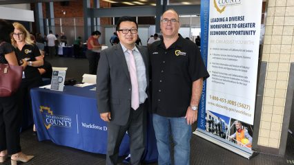 Public Defender Thomas W. Sone and San Bernardino County Supervisor Curt Hagman posing in front of job fair.