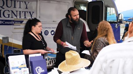 Public Defender staff assist community members with paperwork outside the Mobile Defense Unit at an outreach event.