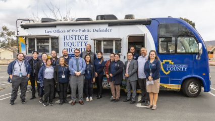 Public Defender staff stand in front of the Mobile Defense mobile unit at the Joshua Tree Community Center.