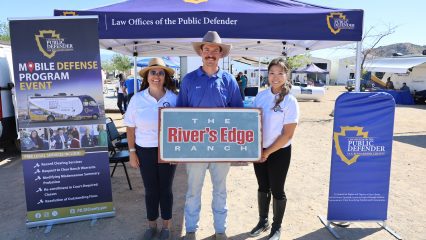 Public Defender staff host outreach booth in front of canopy, sharing resources at Mobile Defense event at The River’s Edge Ranch.